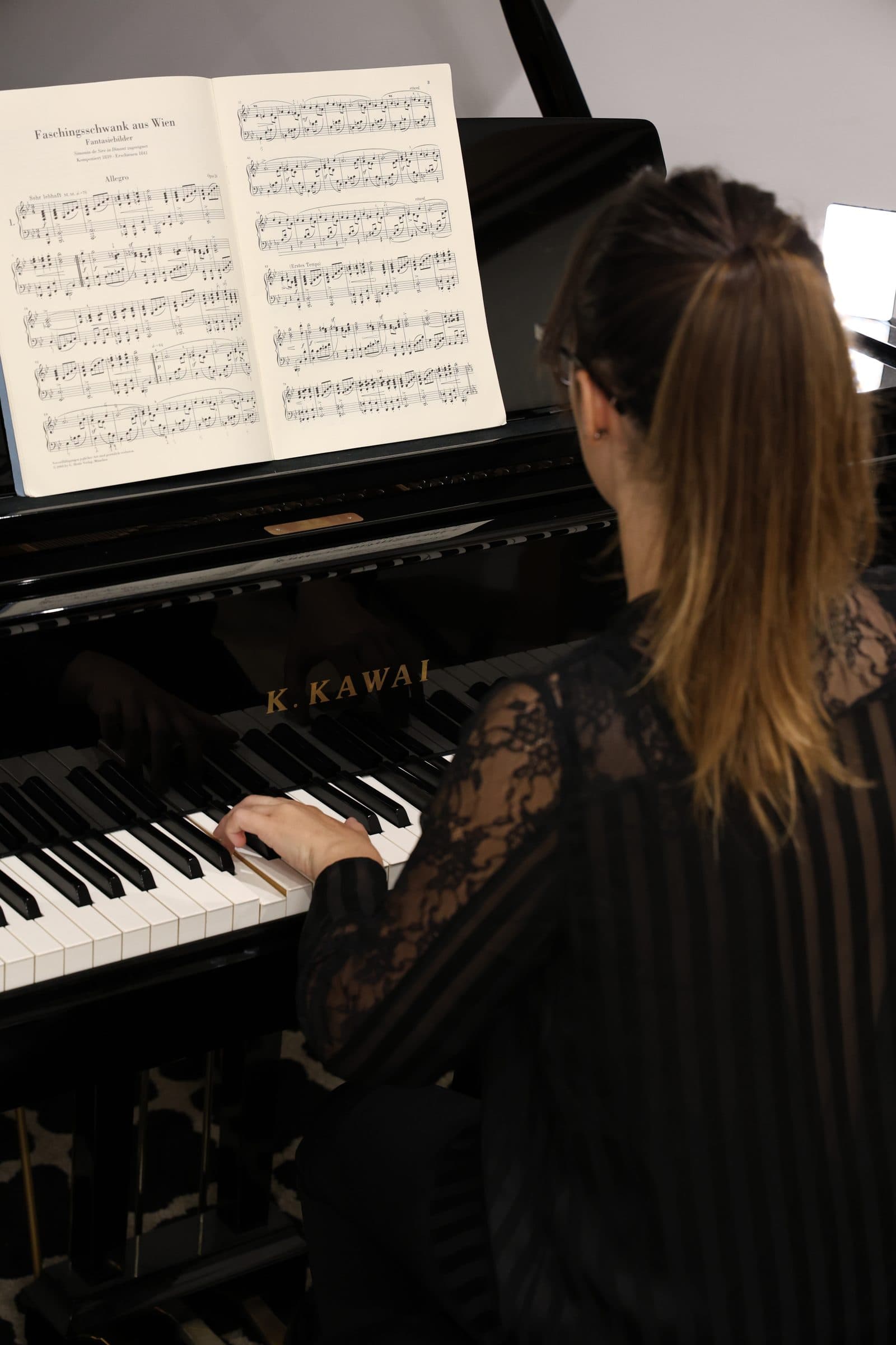Laura Ortega sentada al piano de cola Kawai GX-2