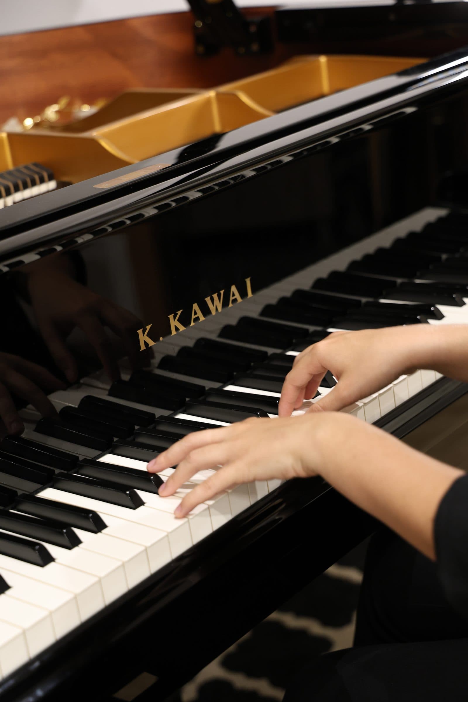 Laura Ortega sentada a su piano de cola Kawai GX-2 en el estudio de Barcelona
